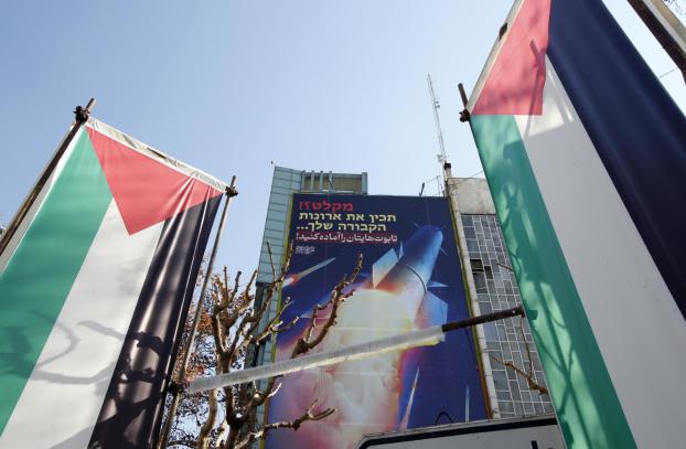 Tehran (Iran(islamic Republic Of)), 15/01/2024.- Palestinian flags and a billboard depicting Iranian missiles with a message in Persian and Hebrew reading: 'prepare your coffins', hangs on a building at Palestine square in Tehran, Iran, 16 January 2024. According to Iranian revolutionary guard corps (IRGC), Iran had a several missile strike to ''terrorist and ISIS bases in Northern Iraq and Syria" last night,and claims that it destroyed "Israel spy bases" in Erbil, Iraq. (Terrorista, Siria, Teherán) EFE/EPA/ABEDIN TAHERKENAREH