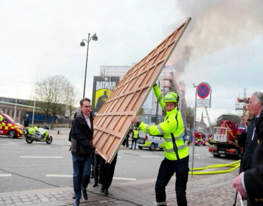Varias personas ayudan a sacar las obras de arte de gran valor del interior del edificio incendiado de la Bolsa de Copenhague.