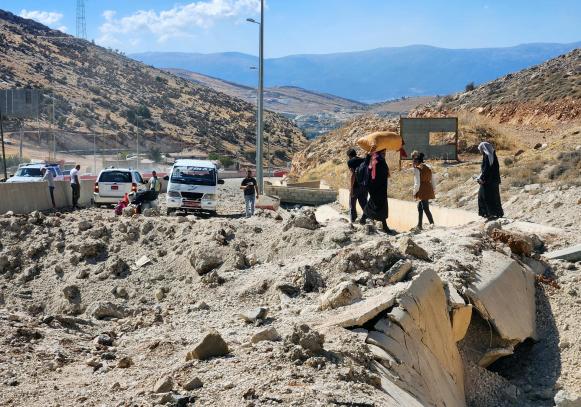 Desplazados cruzando la carretera que une las fronteras entre Líbano y Siria.