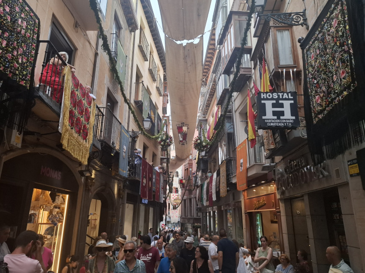 Las calles de Toledo se engalan por el paso de la Custodia de Arfe.