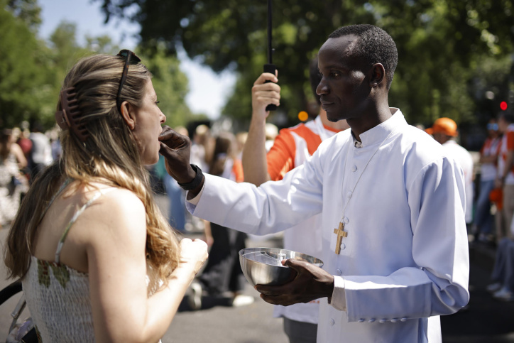 MADRID, 07/06/2026.- Sacerdotes voluntarios dan la eucaristía en la calle Alcalá durante la misa del Corpus Christi oficiada por papa León XIV este domingo en la Plaza de Cibeles de Madrid. EFE/ Marcos Villaoslada