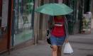 Una mujer se protege de la lluvia con un paraguas