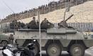 El ejército desplegando en la frontera del Tarajal en Ceuta ante la atenta mirada de los inmigrantes este viernes, donde se han registrado violentos enfrentamientos en los perímetros fronterizos durante su intento de acceder desde Marruecos hacia Ceuta y Melilla.