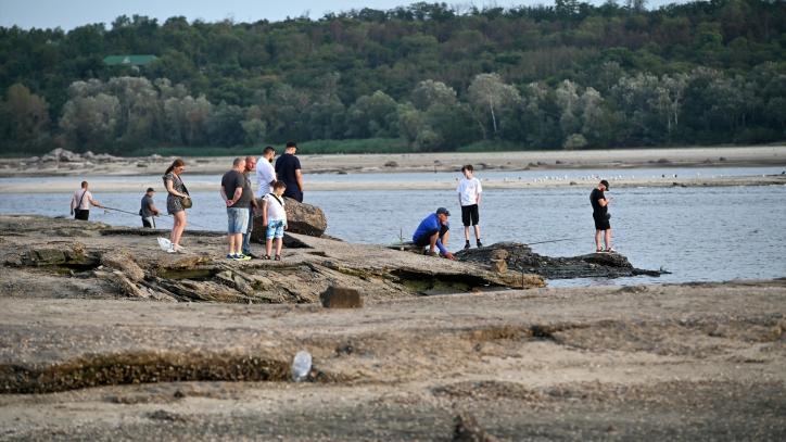 Los miembros del público se relajan junto al río Dnipro después de que el agua retrocediera debido a que los ocupantes rusos volaron la represa Kakhovka el 6 de junio de 2023, Zaporizhzhia, sureste de Ucrania.