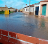 Calles como canales y agua saliendo de los desagües y otros efectos de la crecida del Bullaque en El Robledo
