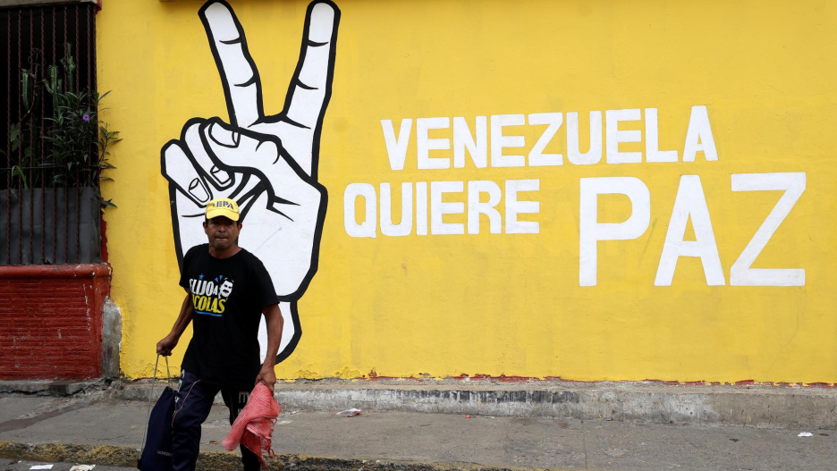 AME2123. CARACAS (VENEZUELA), 24/11/2025.- Un hombre camina frente a un mural este lunes, en Caracas (Venezuela). EFE/ Ronald Peña R