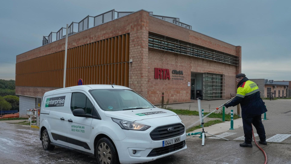 GRAFCAT5345. BELLATERRA (BARCELONA) (ESPAÑA), 05/12/2025.- ¿Salió el virus de la peste porcina africana de un laboratorio? El Gobierno lo está investigando, pero ante esta hipótesis todas las miradas se dirigen ahora al Centro de Investigación en Sanidad Animal (IRTA-CReSA) de Bellaterra, institución que lleva casi dos décadas estudiando este agente patógeno y que está situada muy cerca de donde se detectó el brote.En la imagen un Mosso d'Esquadra desinfecta un vehículo en las inmediaciones del Centro el pasado 4 de diciembre. EFE/ Enric Fontcuberta