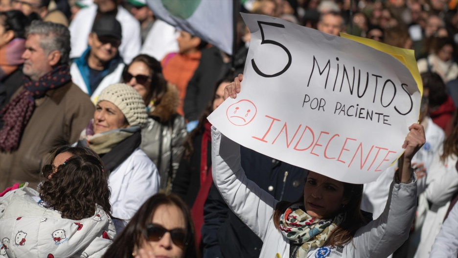 Manifestante porta pancarta con lema '5 minutos por paciente. Indecente' durante la manifestación contra el Estatuto Marco del Ministerio de Sanidad este sábado.