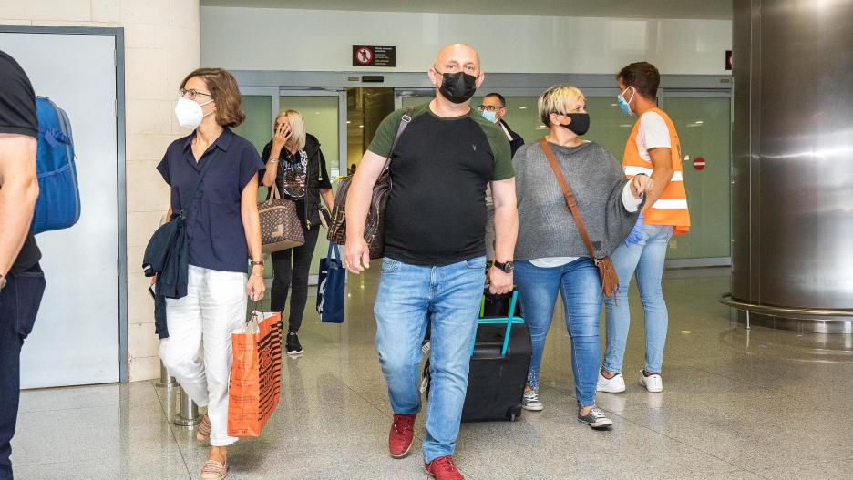 Pasajeros procedentes del primer vuelo con origen Gran Bretaña desde que el país incluyó a Baleares en la lista verde de viajes de riesgo por la COVID-19, salen del Aeropuerto de Menorca, a 1 de julio de 2021, en Menorca, Islas Baleares, (España). El pasa