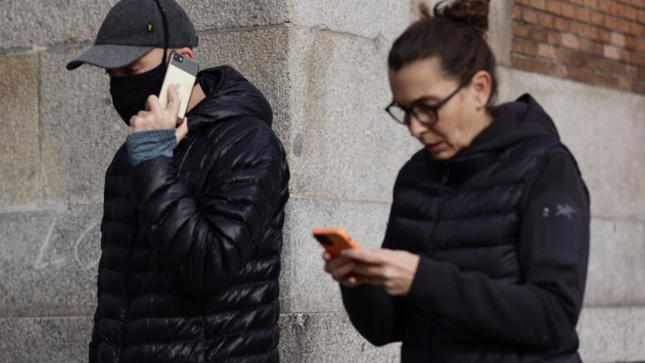 Un hombre camina con mascarilla y una mujer sin mascarilla, a 4 de febrero de 2022, en Madrid (España). El Gobierno, en Consejo de Ministros, eliminará el uso de las mascarillas en exteriores el próximo martes, 8 de febrero, y la medida entrará en vigor e