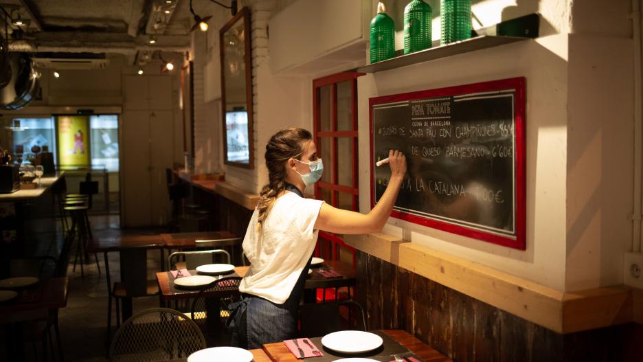 Una camarera apunta platos en una pizarra en el interior de un bar en una calle céntrica de Barcelona, a 14 de octubre de 2021, en Barcelona, Catalunya (España). A partir de este viernes en Cataluña se terminarán las limitaciones de aforo en los equipamie