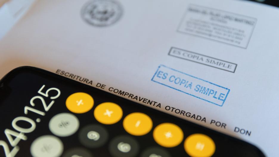Una calculadora y una escritura de compraventa de una hipoteca, a 2 de junio de 2022, en Madrid (España). Los portales inmobiliarios han destacado el crecimiento del 18% en la firma de hipotecas sobre viviendas hasta su mayor cifra en 11 años (43.378 prés