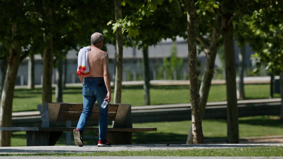 Un hombre camina sin camiseta el día en que España comenzará a sufrir un "importante" episodio cálido con temperaturas de pleno verano, a 17 de mayo de 2022, en Madrid (España). Algunas zonas de la península rozarán los 40 grados centígrados y noches trop