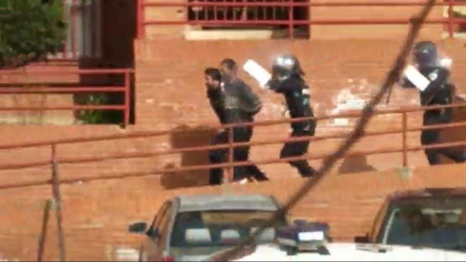 Momento en el que el presunto asesino del joven de 30 años en el Polígono de Toledo sale escoltado con efectivos de antidisturbios