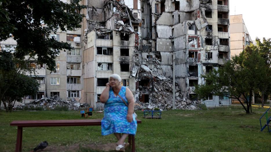 Kharkiv (Ukraine), 31/08/2023.- A woman talks on the phone while sitting on a bench in front of a damaged apartment block, previously hit by a Russian missile strike, in Kharkiv, Ukraine, 31 August 2023. Russian troops entered Ukrainian territory in February 2022, starting a conflict that has provoked destruction and a humanitarian crisis. (Rusia, Ucrania) EFE/EPA/CATHAL MCNAUGHTON