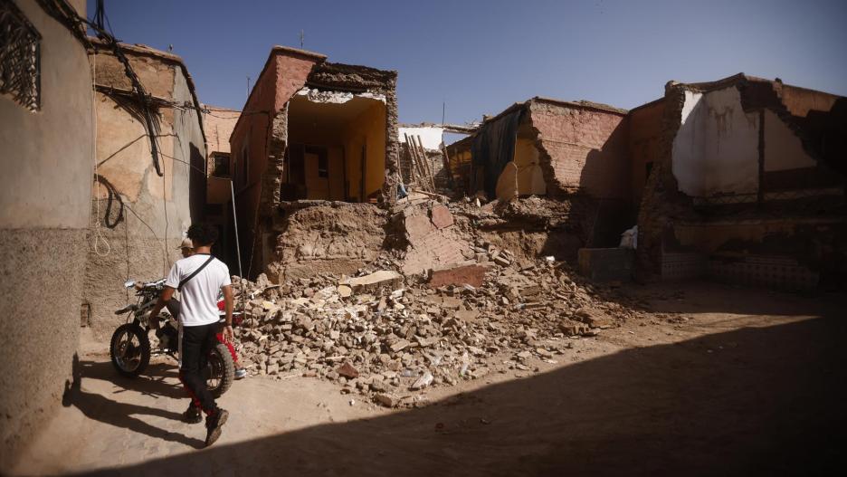 Los adolescentes empujan una motocicleta por edificios dañados dentro de la Medina después de un poderoso terremoto en Marrakech, Marruecos, 12 de septiembre de 2023.