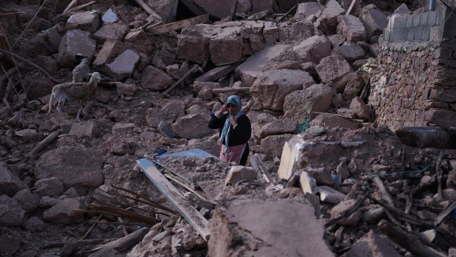 Una mujer camina por un pueblo destruido por el terremoto.
