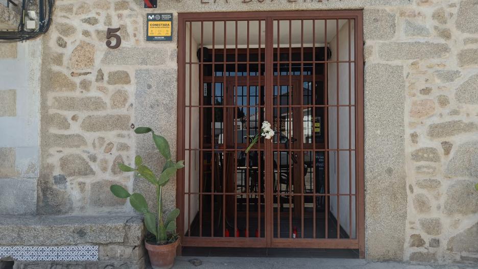 Flores en la puerta del bar regentado por la mujer hallada muerta este domingo en Pelahustán