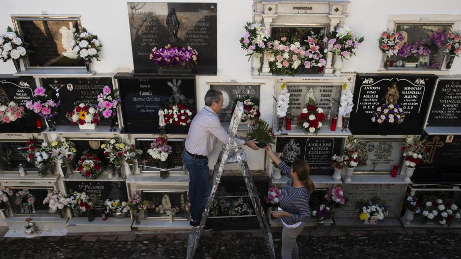 CASABERMEJA (MÁLAGA), 01/11/2023.- Unas personas colocan flores en un nicho en el cementerio de Casabermeja (Málaga), este miércoles. EFE/ Jorge Zapata