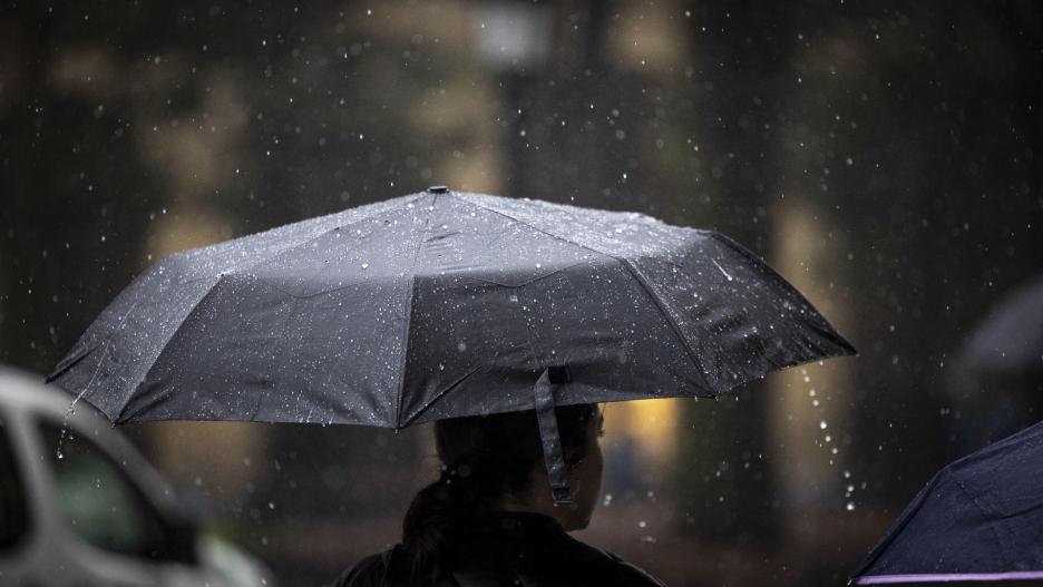 SAN SEBASTIÁN, 15/01/2024.- Una mujer camina con su paraguas bajo la lluvia