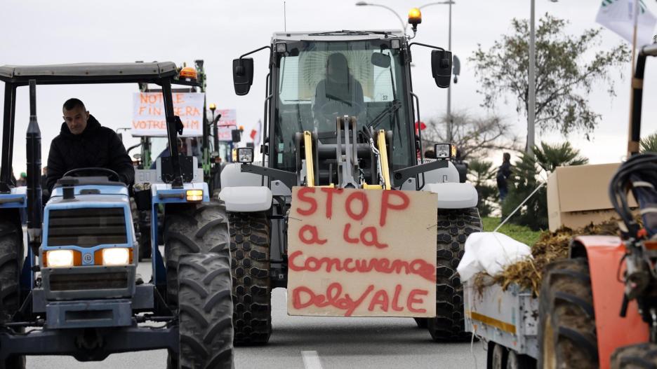 Niza (France), 26/01/2024.- Un tractor con una pancarta "Detener la competencia desleal" durante la protesta de los agricultores en una carretera cerca de Niza, Francia, 26 de enero de 2024. Los agricultores franceses continúan sus protestas con bloqueos de carreteras y manifestaciones frente a edificios estatales a la espera de una respuesta del gobierno a su solicitud de ayuda "inmediata" de varios cientos de millones de euros. El 23 de enero, el Consejo de Agricultura y Pesca de la UE destacó la importancia de proporcionar las condiciones necesarias para que los agricultores de la UE puedan garantizar la seguridad alimentaria de forma sostenible y rentable, así como garantizar unos ingresos justos para los agricultores. EFE/EPA/SEBASTIEN NOGIERA