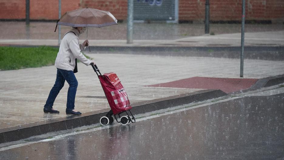 Una mujer regresa de hacer la compra en plena lluvia durante el Estado de Alarma decretado por el Gobierno de España con motivo del coronavirus COVID-19. En Pamplona, Navarra, España, a 25 de abril de 2020.