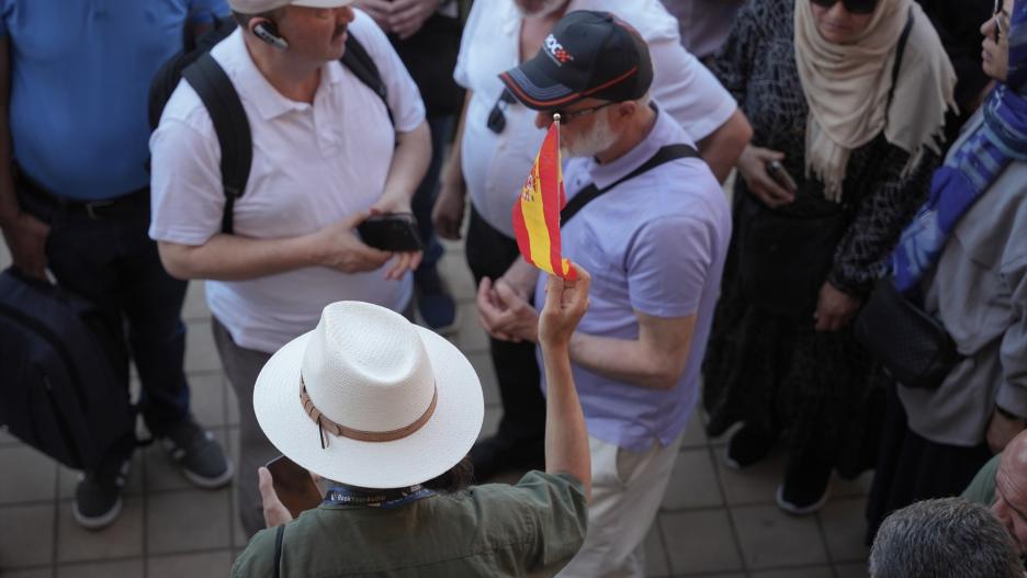 Un guía turístico sujeta una bandera de España