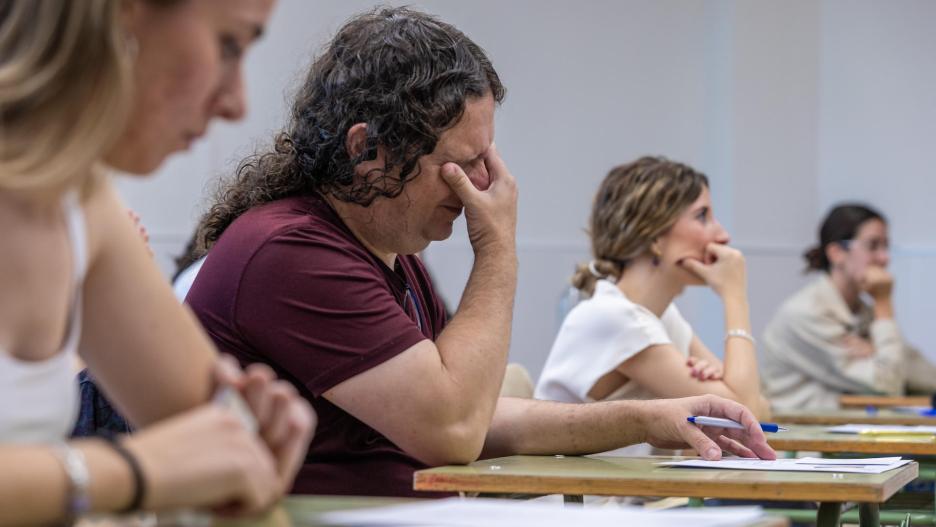 Varias personas esperan al comienzo de su examen del proceso de oposición del Cuerpo de Maestros del año 2024 en el IES Universidad Laboral de Toledo.