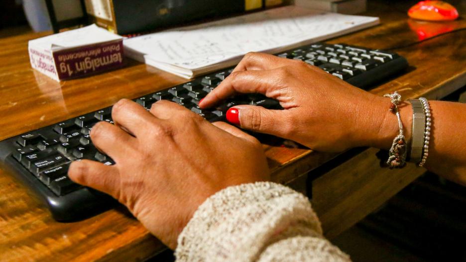 Unas manos de mujer escriben en el teclado de un ordenador