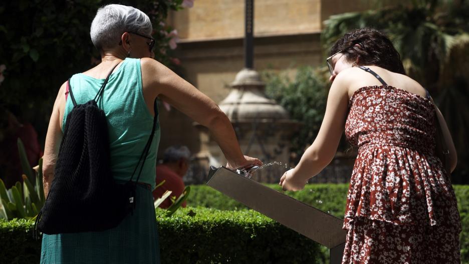 Dos mujeres  recoge agua de una fuente para combatir la ola de calor que estos días azota la capital a 19 de julio e 2023 en Málaga, Andalucía. La Agencia Estatal de Meteorología (Aemet) ha activado para este miércoles el aviso rojo por altas temperaturas en la provincia de Málaga, donde se pueden alcanzar los 42 grados en el litoral
Álex Zea / Europa Press
(Foto de ARCHIVO)
19/7/2023