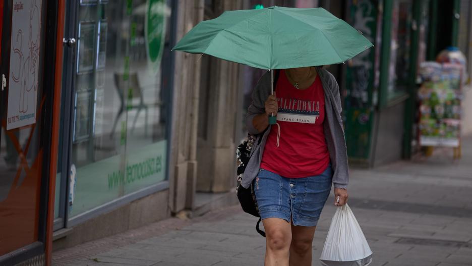 Una mujer se protege de la lluvia con un paraguas