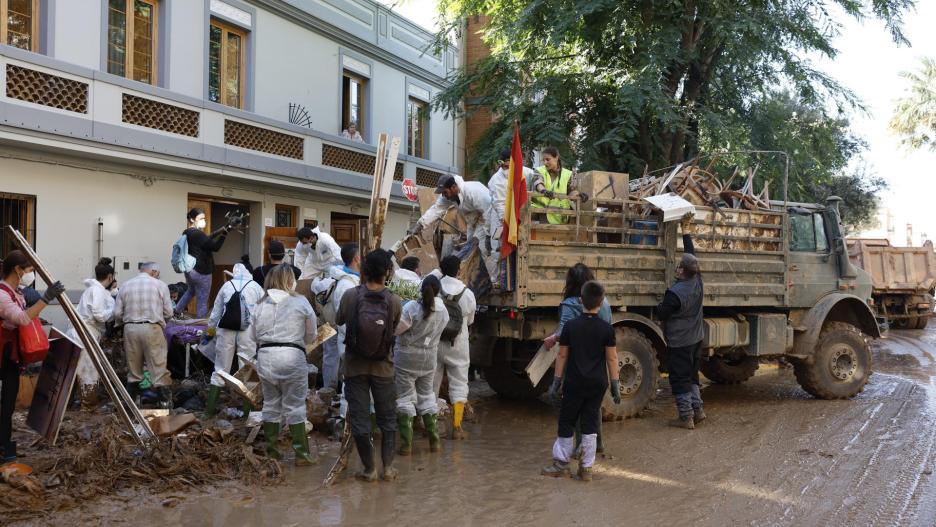 Voluntarios limpian una calle en Paiporta (València), este domingo.