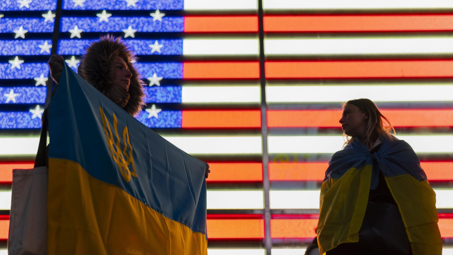 NEW YORK (United States), 24/02/2025.- Anya Kostyk (L) holds a Ukrainian flag during a demonstration in support of Ukraine to mark the third anniversary of the Russian invasion and ongoing war, in Times Square in New York, New York, USA, 24 February 2025. In recent days, US President Donald Trump has signaled a significant shift in the US foreign policy alignment to Ukraine and Russia. (Rusia, Ucrania, Nueva York) EFE/EPA/JUSTIN LANE