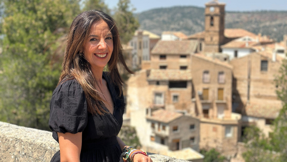 La directora y presentadora de "Castilla-La Mancha Me Gusta", Esperanza Santos, con el casco histórico de Letur al fondo.