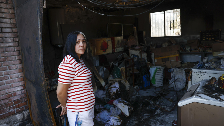 CASARRUBIOS DEL MONTE (TOLEDO) 18/07/2025.- Una mujer observa el estado de una vivienda de la urbanización Calypo Fado de la localidad toledana de Casarrubios del Monte. El incendio que se originó en Méntrida (Toledo) a primera hora de la tarde de ayer ha arrasado unas 3.000 hectáreas en pocas horas y avanzó hacia las localidades madrileñas de Navalcarnero y Villamanta, desalojando a unas 50 personas como medida preventivas. EFE/ Chema Moya