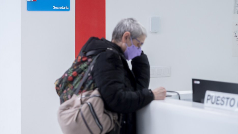 Una mujer con mascarilla en un centro hospitalario.