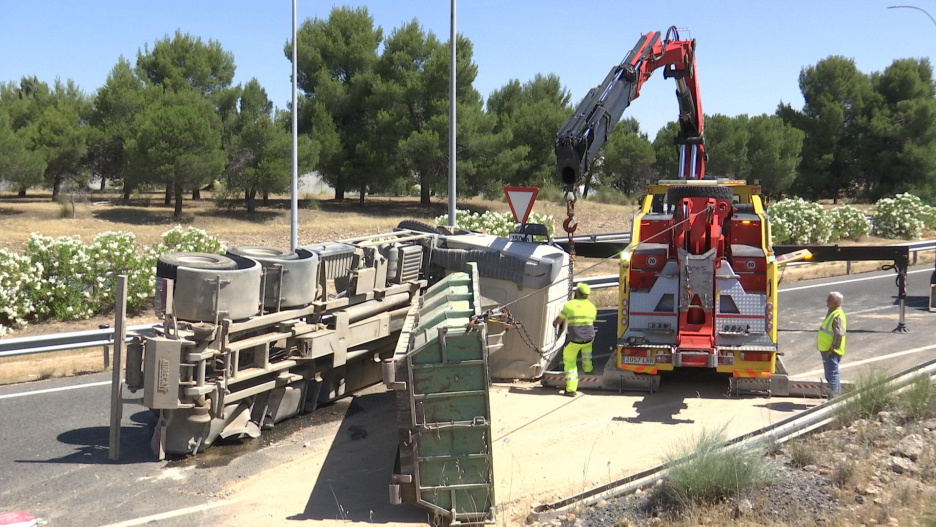 Una grúa de grandes dimensiones trabaja en la retirada del vehículo de la calzada.
