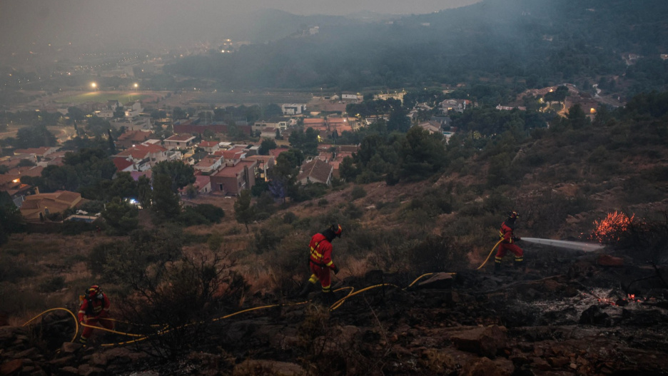 Miembros de la UME trabajan en La Vall d'Uixò a primera hora de hoy domingo donde continúa el incendio forestal declarado este sábado en este municipio castellonense y que ha obligado al desalojo de mas de 16.000 `personas de modo preventinvo ante la evolución del fuego. EFE/Manuel Bruque