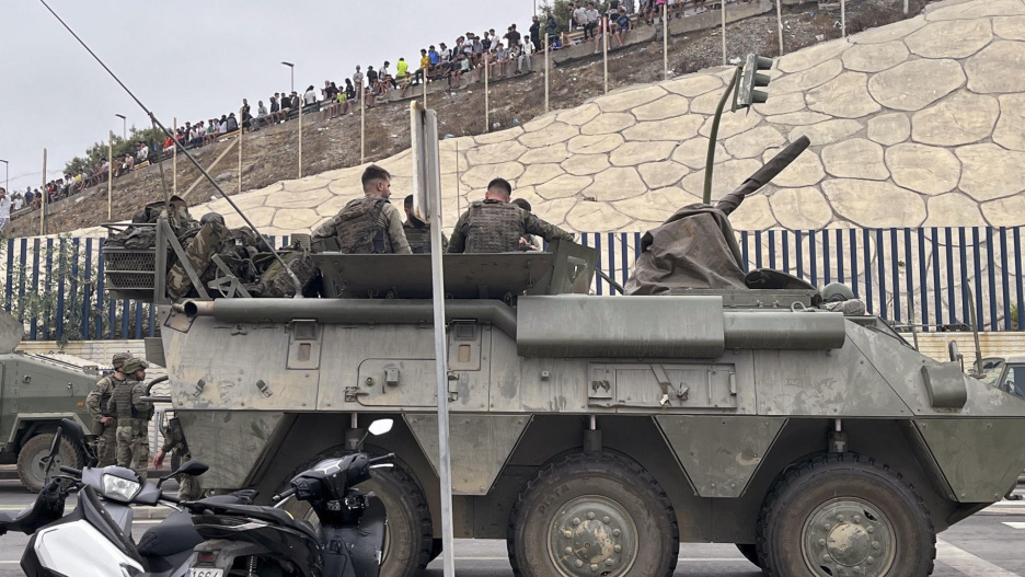 El ejército desplegando en la frontera del Tarajal en Ceuta ante la atenta mirada de los inmigrantes este viernes, donde se han registrado violentos enfrentamientos en los perímetros fronterizos durante su intento de acceder desde Marruecos hacia Ceuta y Melilla.