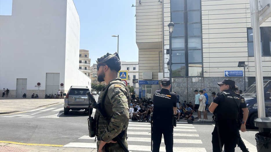 Varios militares dan apoyo a efectivos de la Policía Nacional al lado de una comisaría en la que un grupo de menores espera para ser filiado, a 10 de agosto de 2026, en Ceuta (España). La ciudad acoge a miles de personas pendientes de retorno, entre ellas más de 1.300 menores, mientras las convocatorias difundidas en redes sociales hacen temer una nueva entrada masiva de migrantes.

Gabriela Sardá Núñez / Europa Press
10 AGOSTO 2026;MARRUECOS;MIGRACIONES;MENORES NO ACOMPAÑADOS;FRONTERAS;INMIGRACIÓN;MIGRANTES;INMIGRANTES
10/8/2026