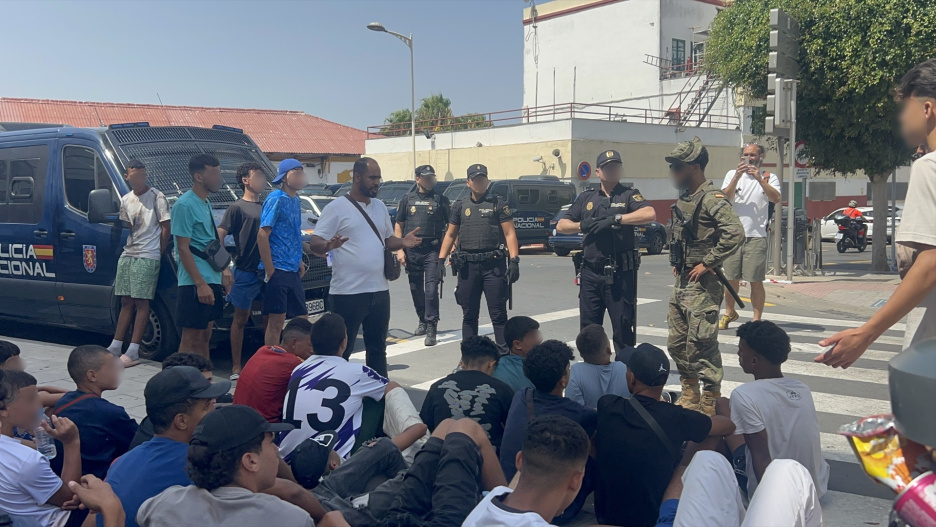 (Foto de ARCHIVO)
Varios militares dan apoyo a efectivos de la Policía Nacional al lado de una comisaría en la que un grupo de menores espera para ser filiado, a 10 de agosto de 2026, en Ceuta (España). La ciudad acoge a miles de personas pendientes de retorno, entre ellas más de 1.300 menores, mientras las convocatorias difundidas en redes sociales hacen temer una nueva entrada masiva de migrantes.

Gabriela Sardá Núñez / Europa Press
10 AGOSTO 2026;MARRUECOS;MIGRACIONES;MENORES NO ACOMPAÑADOS;FRONTERAS;INMIGRACIÓN;MIGRANTES;INMIGRANTES
10/8/2026