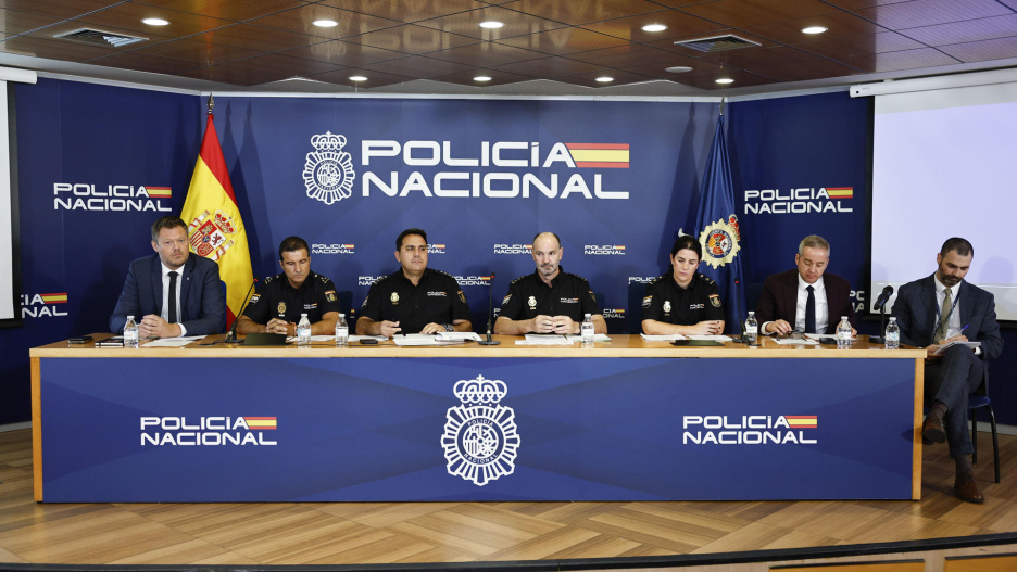 MADRID, 08/09/2026.- (De izq a der) El representante de la Interpol Tobias Bunde, los efectivos de la Policía Nacional Ignacio La Puerta ,el comisario principal de la UDYCO, Alberto Morales, José Rodríguez, Encarna Ortega, y el delegado de Europol Alexander Resch junto a un traductor durante la rueda de prensa para informar de la desarticulación de una de las bancas clandestinas más importantes para la financiación del narcotráfico, un narcobanco conocido como 'banca de Dubai'.