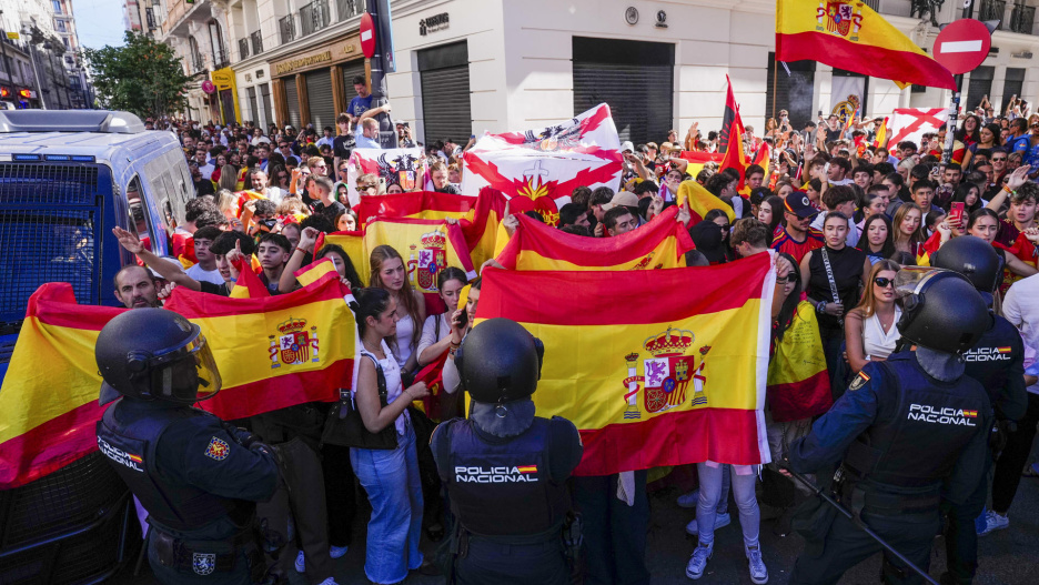 Madrid, 12/10/2026.- La Policía Nacional ha desplegado este lunes un cordón en torno a la acampada de la Puerta del Sol después de que un grupo de manifestantes con banderas de España y al grito de "Ceuta no se vende", se hayan concentrado también en este punto. EFE/Borja Sánchez Trillo
