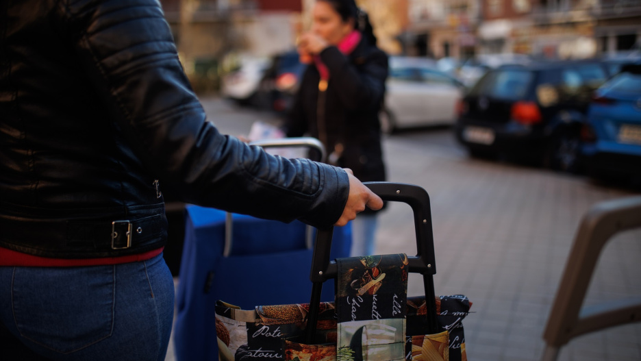 (Foto de ARCHIVO)
Una mujer con un carro de la compra en las colas de gente durante la entrega regalos niños vulnerables.